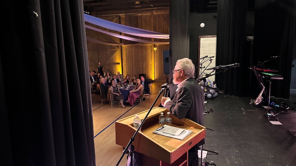 Auctioneer Eric Nathan at the podium in Hunter Hall during Opening New Doors.